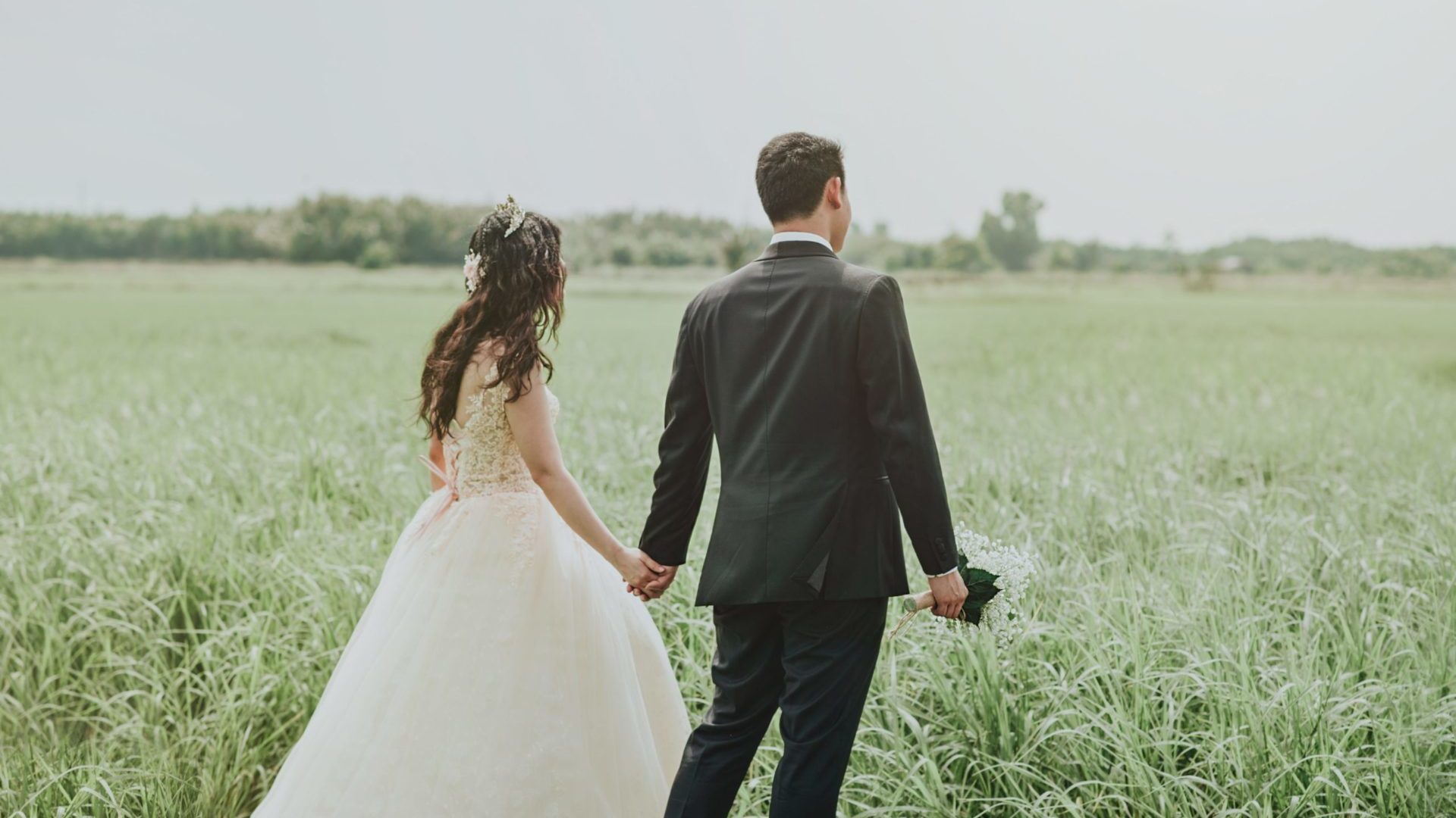 woman-in-white-wedding-dress-holding-hand-to-man-in-black-752842